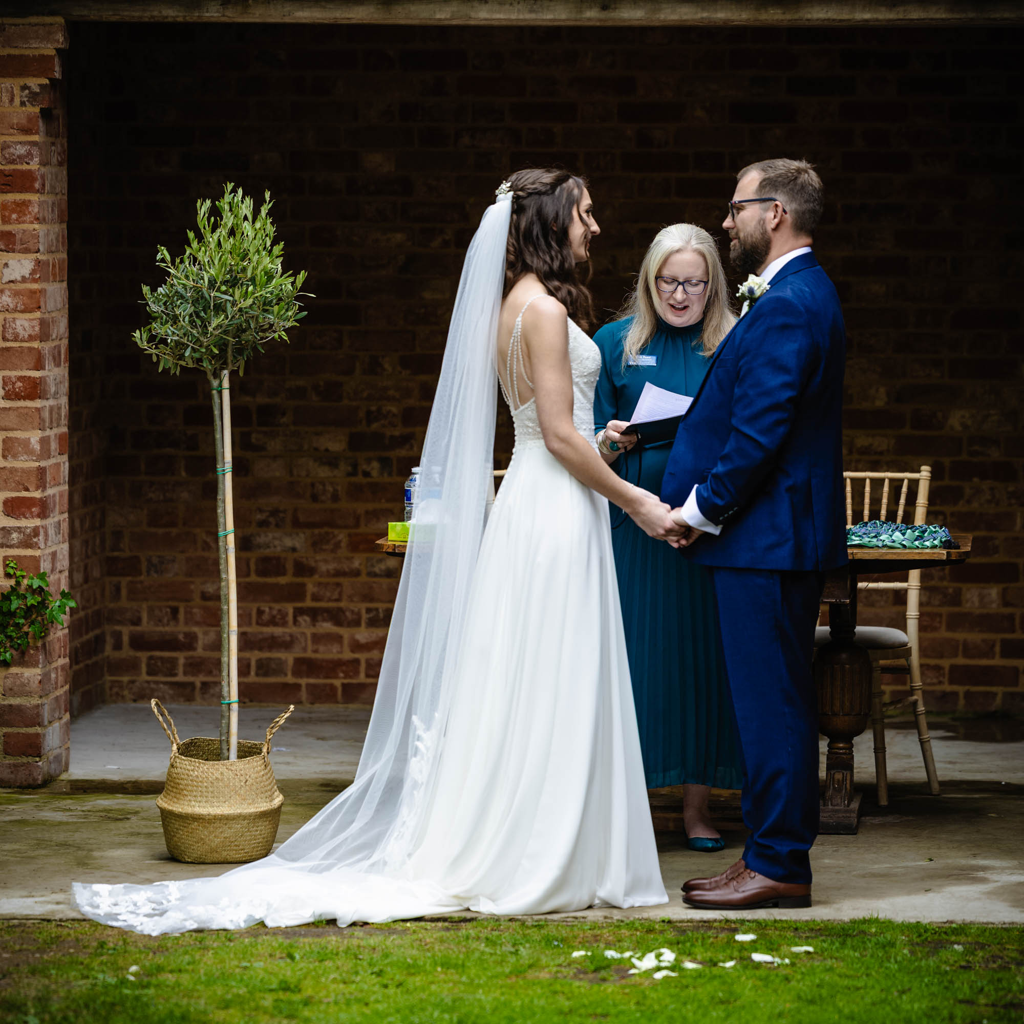 Deb Reed Celebrant Colchester Essex, officiating at the wedding of Cheyney and Albert during their first kiss.